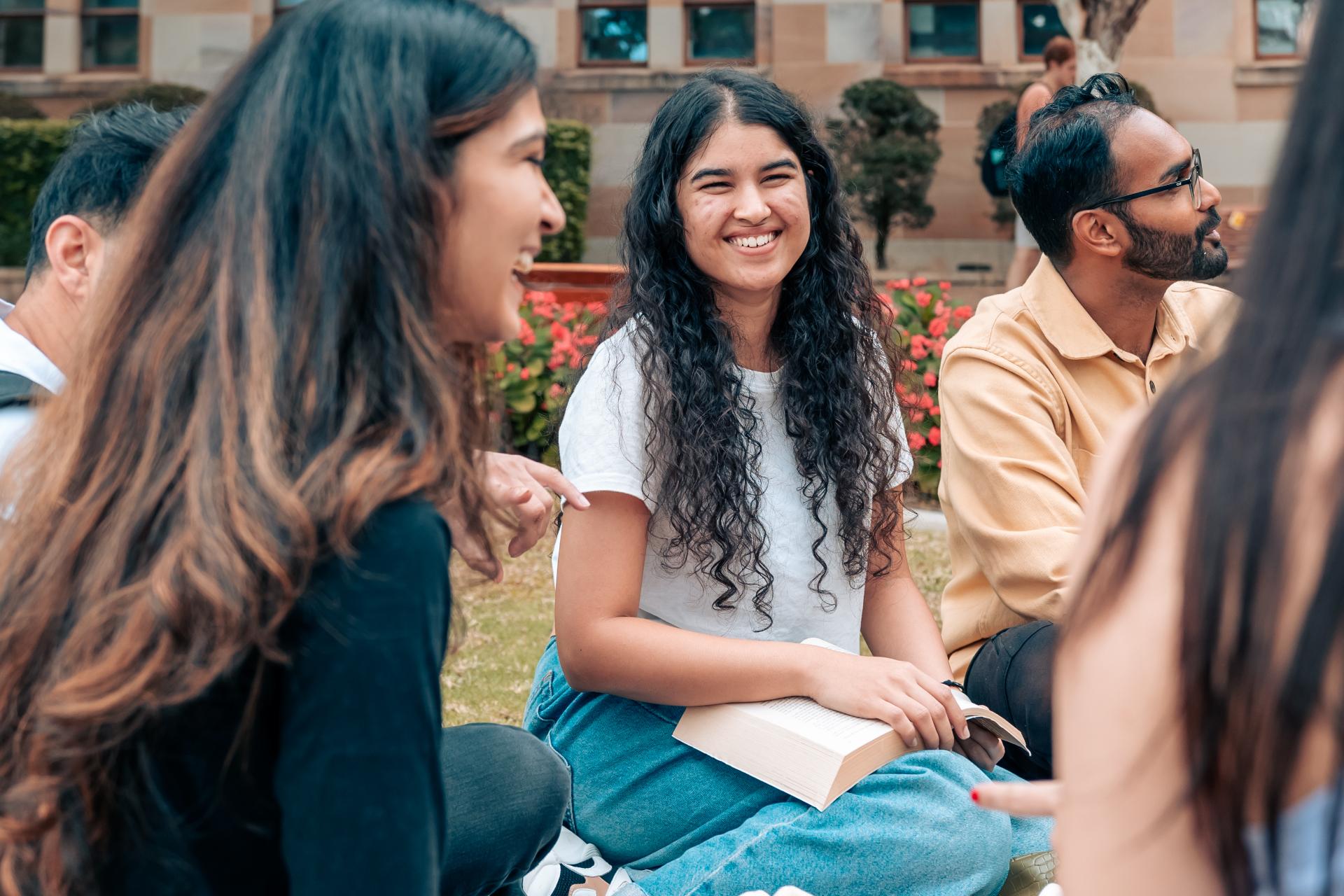 Female student sitting with a group of friends. 