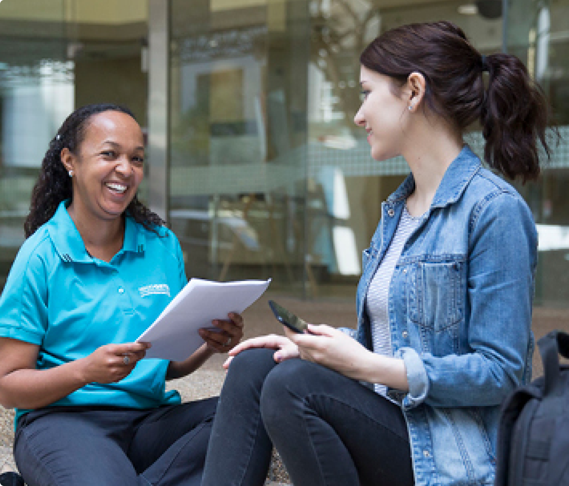 Female student getting advice from a female support officer. 